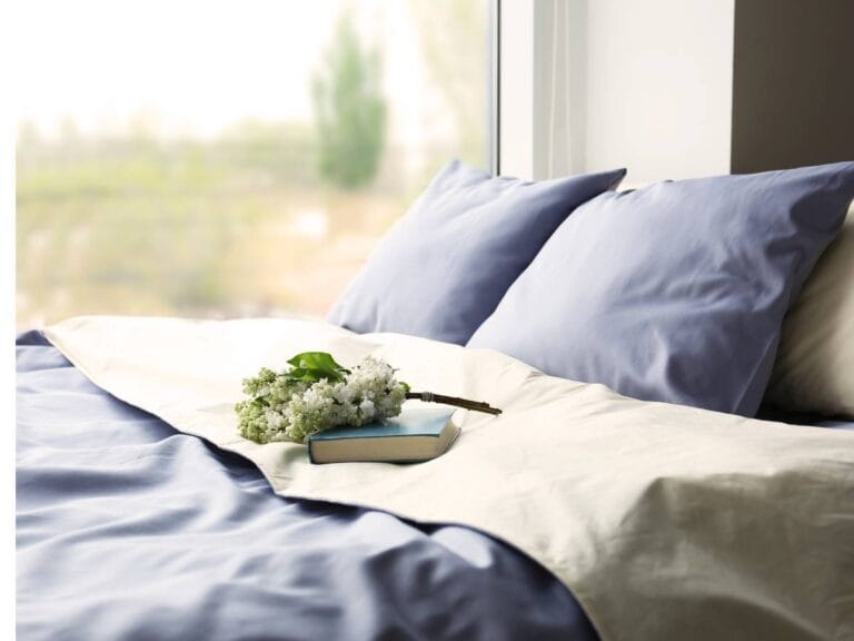 Wezgłowie łóżka z pościelą. Obrazek w artykule W jakiej temperaturze prać pościel? Niezawodne sposoby w jakiej temperaturze prać pościel