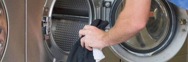 Wkładanie prania. Obrazek w artykule Pralnia samoobsługowa. Co to jest pralnia samoobsługowa i jak działa?