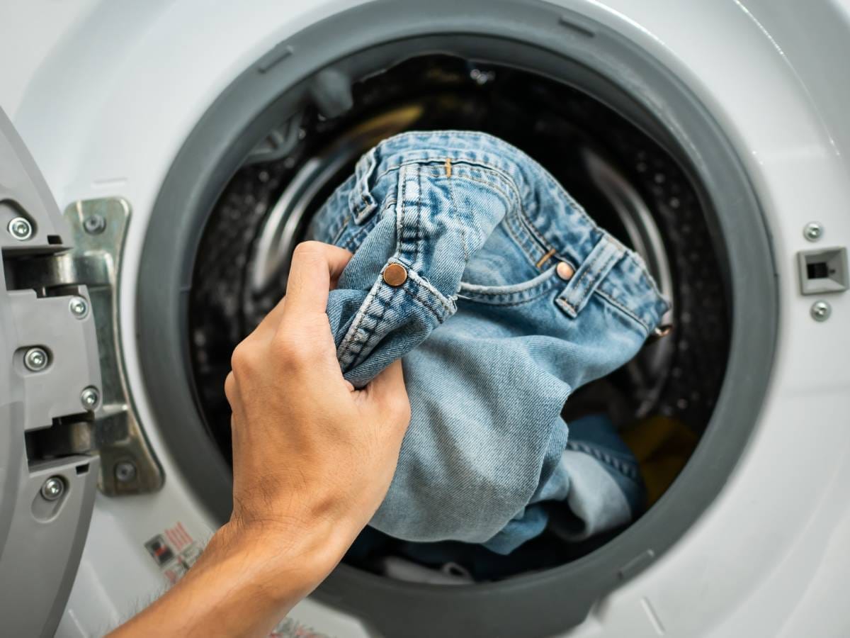 Pralka z jeansami. Obrazek w artykule Jak prać jeansy? Najlepsze sposoby prania jeansów