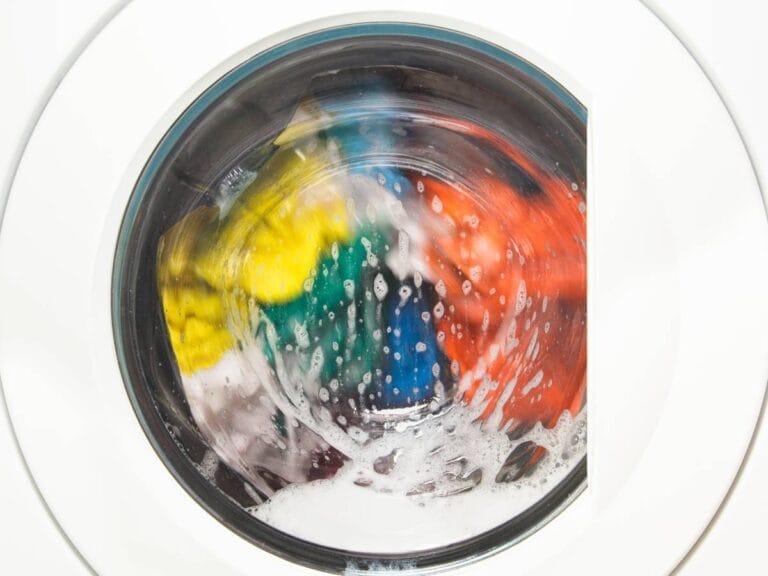 Pralka z kolorowym praniem. Obrazek w artykule Jakie kolory można prać razem? Podpowiedzi jakie kolory można prać razem, żeby nie farbowały