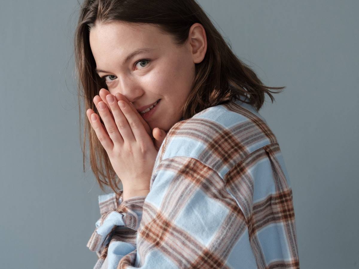 Dziewczyna we flanelowej koszuli w kratkę. Obrazek w artykule Flanela co to za materiał? Wszystko o produkcji, właściwościach i zastosowaniu