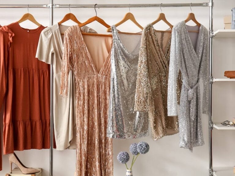 Sukienki rozwieszone do podziwiania na wieszakach. Obrazek w artykule Doradzamy, jakie materiały na sukienki sprawdzą się najlepiej. Odkryj właściwości materiałów sukienkowych