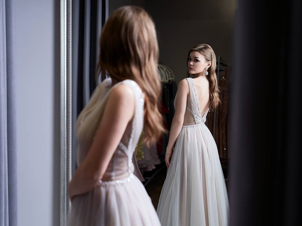 Dziewczyna w lustrze w szyfonowej sukience. Obrazek w artykule Szyfon co to za materiał? Odkryj sekrety produkcji, właściwości i zastosowanie